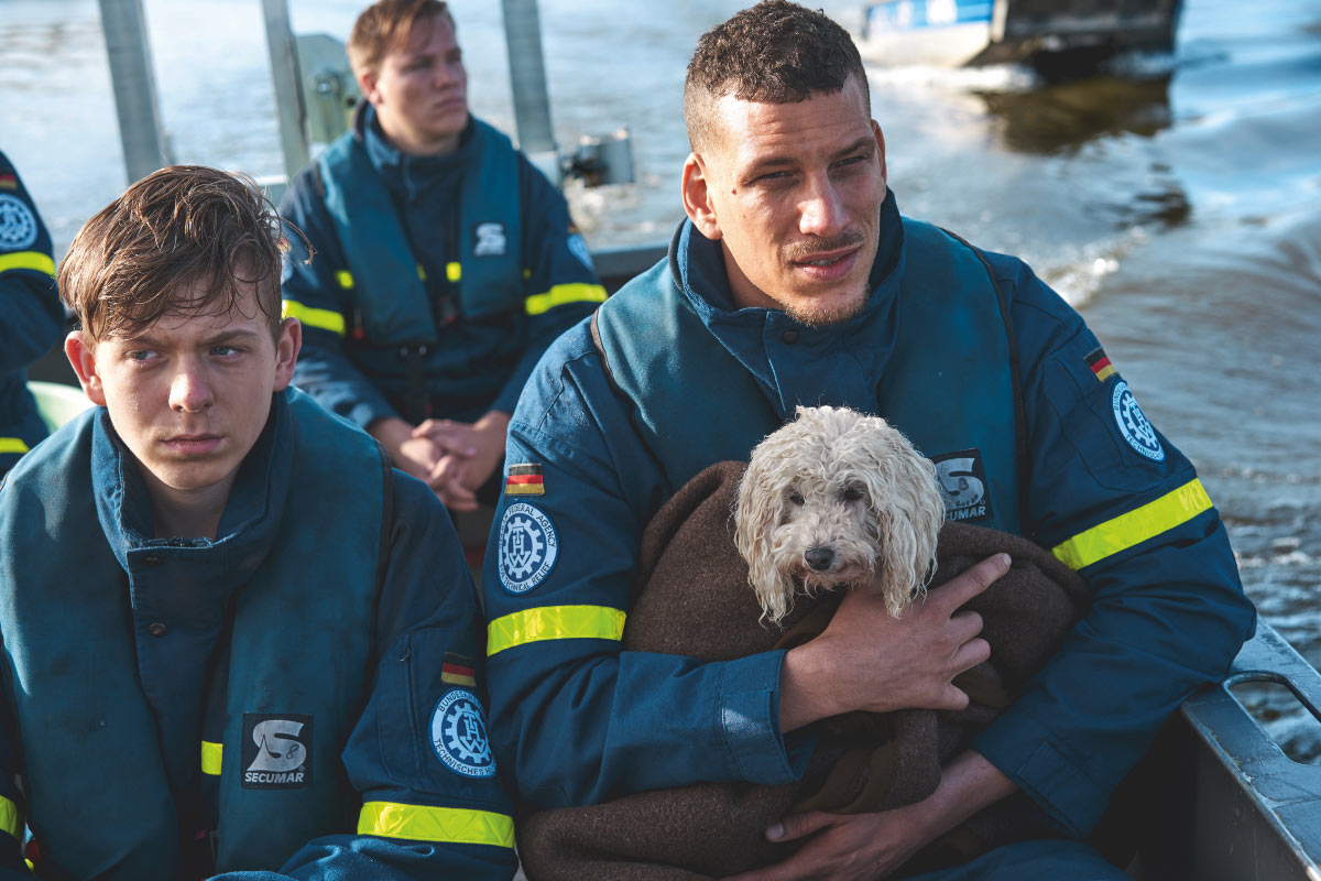 Drei THW-Helfer mit gerettetem Hund in Boot